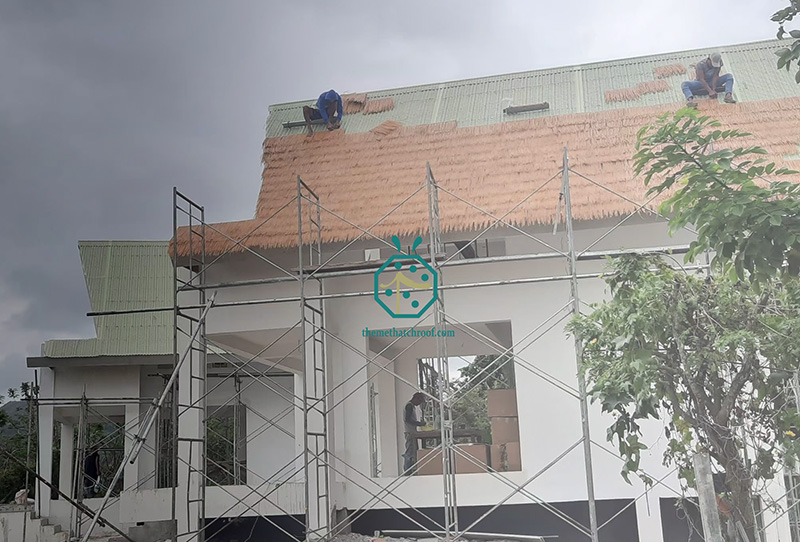 Installation d'un toit de chaume en paille durable par les travailleurs